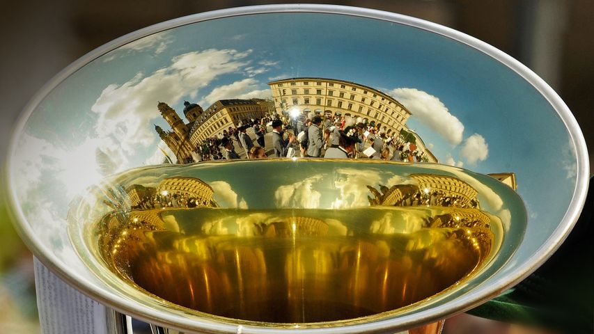 Spiegelung einer Blaskapelle auf dem Schalltrichter einer Tuba beim Trachtenumzug während des Oktoberfests in München, Bayern, Deutschland