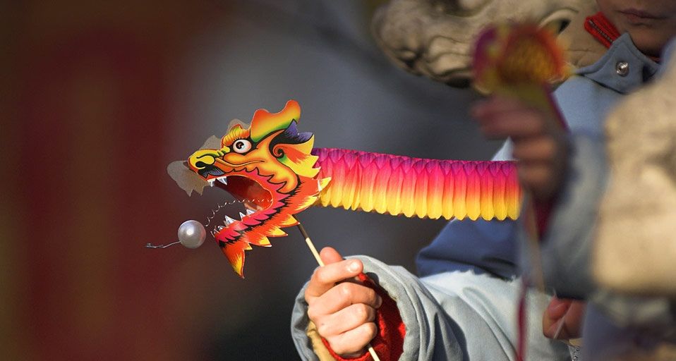 在伦敦庆祝中国新年的小朋友手中拿着纸龙