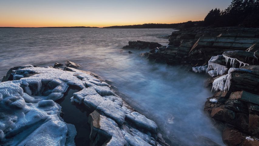 Eisüberzogene Klippen in der Abenddämmerung an der Atlantikküste von Nova Scotia, Kanada 