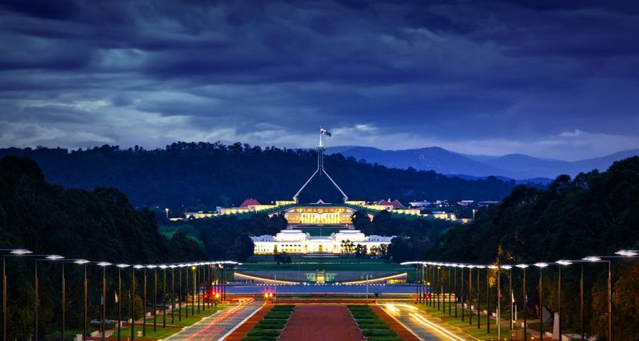 Abendlicher Blick vom australischen Kriegsdenkmal auf das alte und neue Parlament in Canberra, Australien – Jon Hicks/Corbis ©