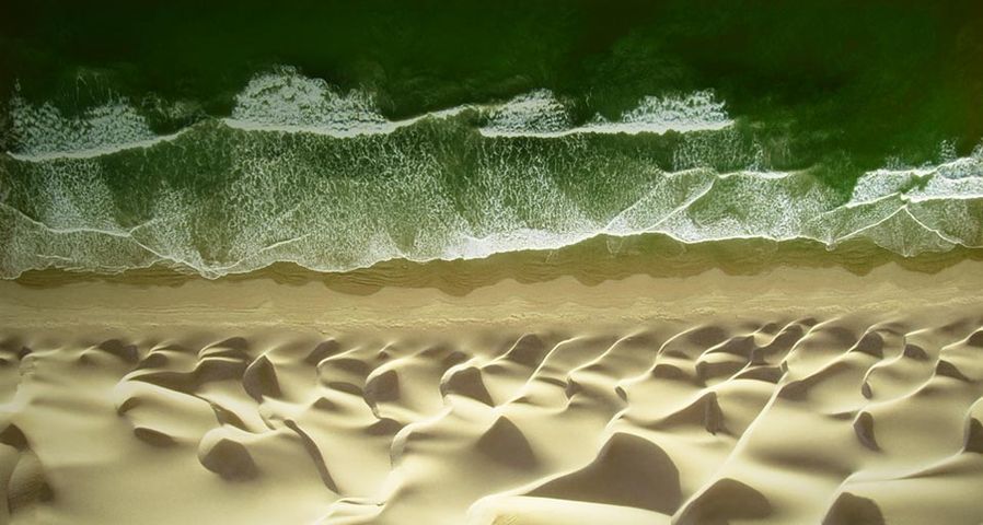 Wasserwellen treffen auf Sandwellen am Strand von Paracas, Peru – George Steinmetz/Corbis ©