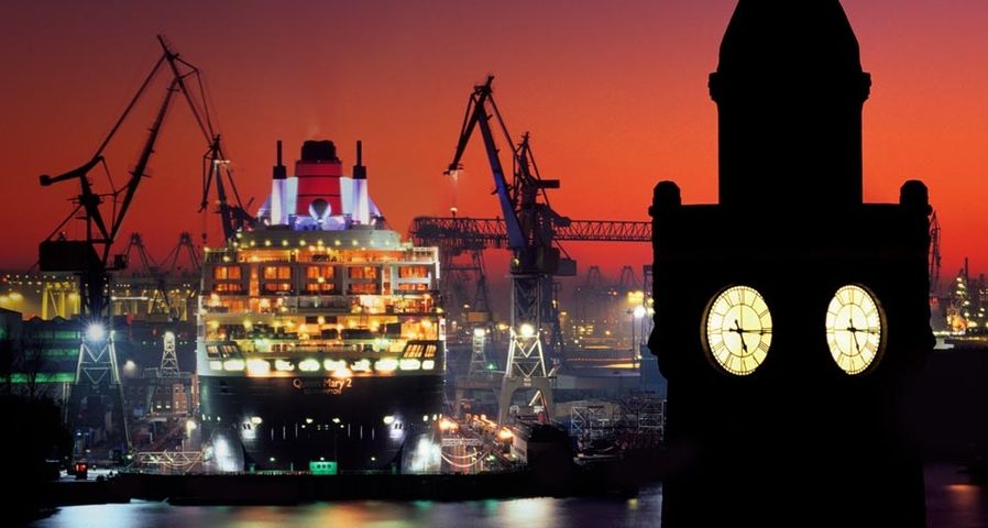 Die Queen Mary 2 im Trockendock des Hamburger Hafens, im Vordergrund der Pegelturm der St. Pauli-Landungsbrücken – Marc Steinmetz/Aurora Photos ©