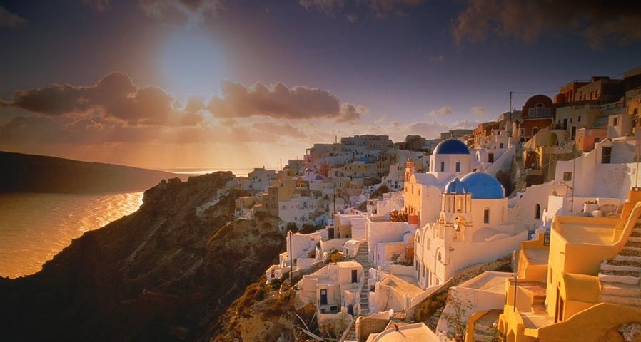 Das Dorf Oia auf der griechischen Insel Santorin bei Sonnenuntergang – Miles Ertman/Masterfile ©
