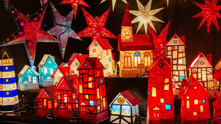 Leuchtende Papierhäuschen and Weihnachtssterne auf einem Weihnachtsmarkt in Hannover, Niedersachsen