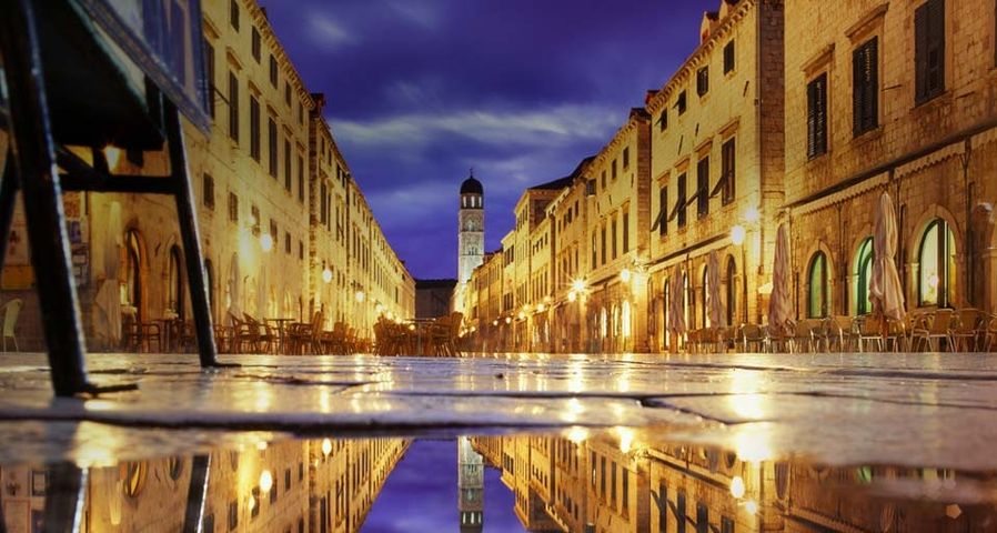 Das nächtlich erleuchtete Dubrovnik spiegelt sich in einer Pfütze, Kroatien