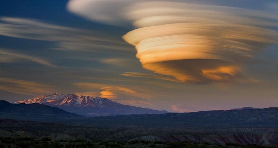 Sonnenuntergang mit Lenticularis-Wolke über einem erloschenen Vulkan in Patagonien, Argentinien