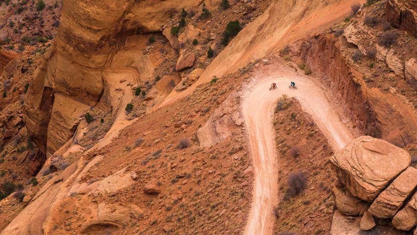 Zwei Mountainbiker auf den Serpentinen des Shafer Trails auf der White Rim Road im Canyonlands-Nationalpark, Utah, USA