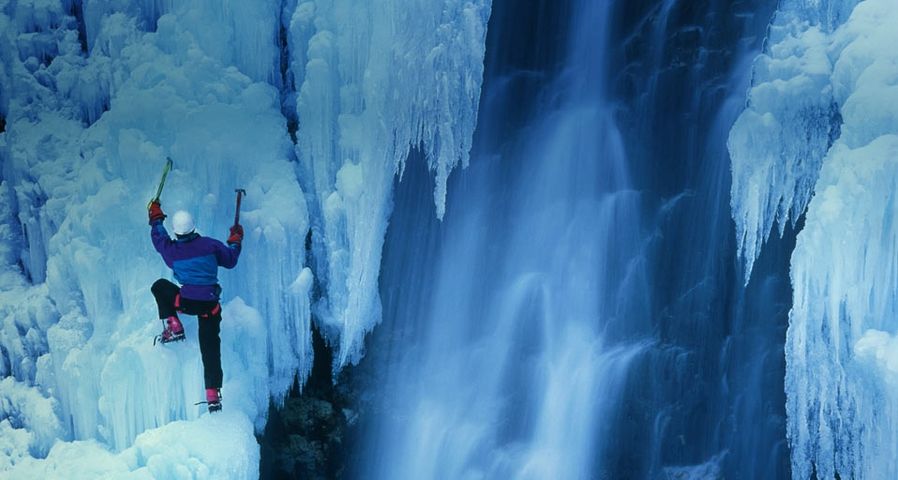 Ein Eiskletterer erklimmt einen gefrorenen Wasserfall in Telluride, Colorado