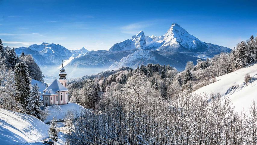 Idyllische Winterlandschaft in den Alpen mit Blick auf die Wallfahrtskirche Maria Gern und den Watzmann, Bayern, Deutschland 