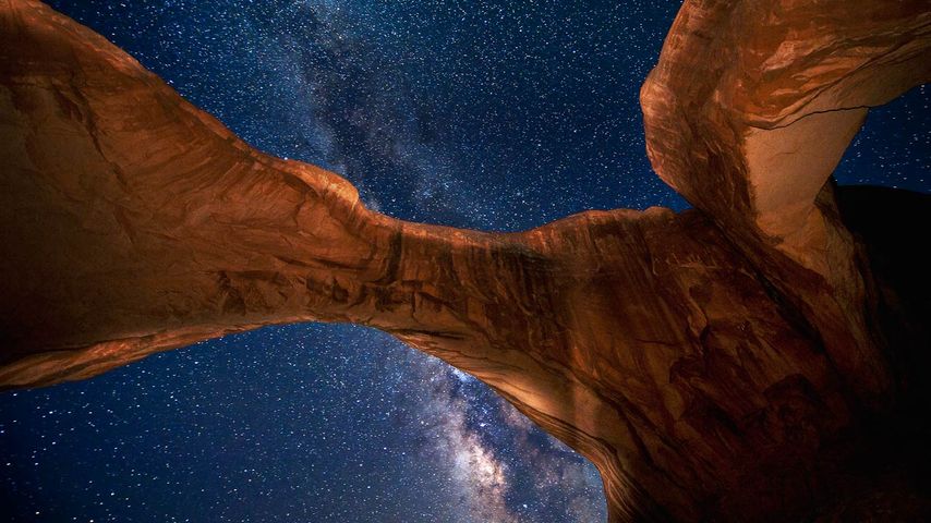 Die Milchstraße über dem Double Arch im Arches-Nationalpark, Utah, USA