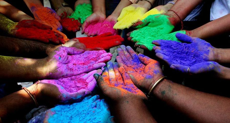 Menschen mit Pulverfarben in Vorbereitung auf das Holi-Fest (Frühlings- und Farbenfest) in Ahmedabad, Indien